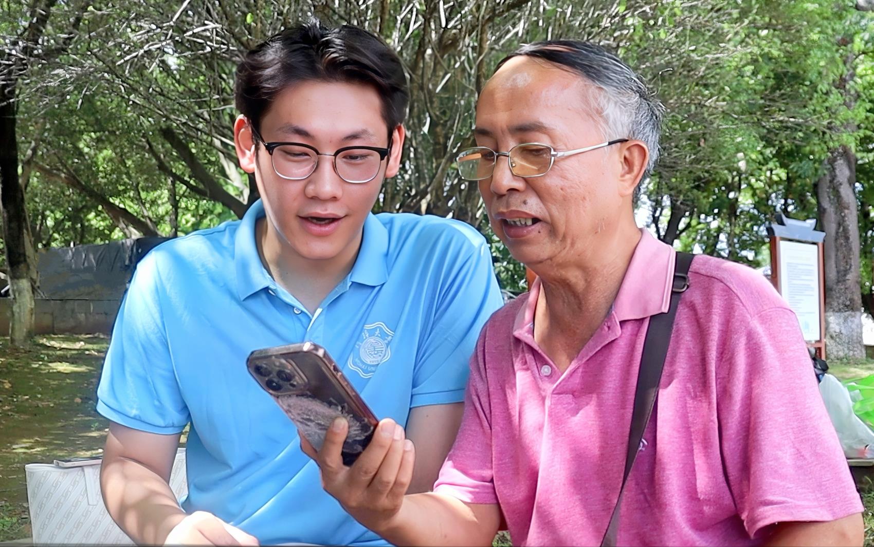 圖為實(shí)踐團(tuán)成員與當(dāng)?shù)乩先艘黄饘W(xué)習(xí)誦讀古詩(shī)